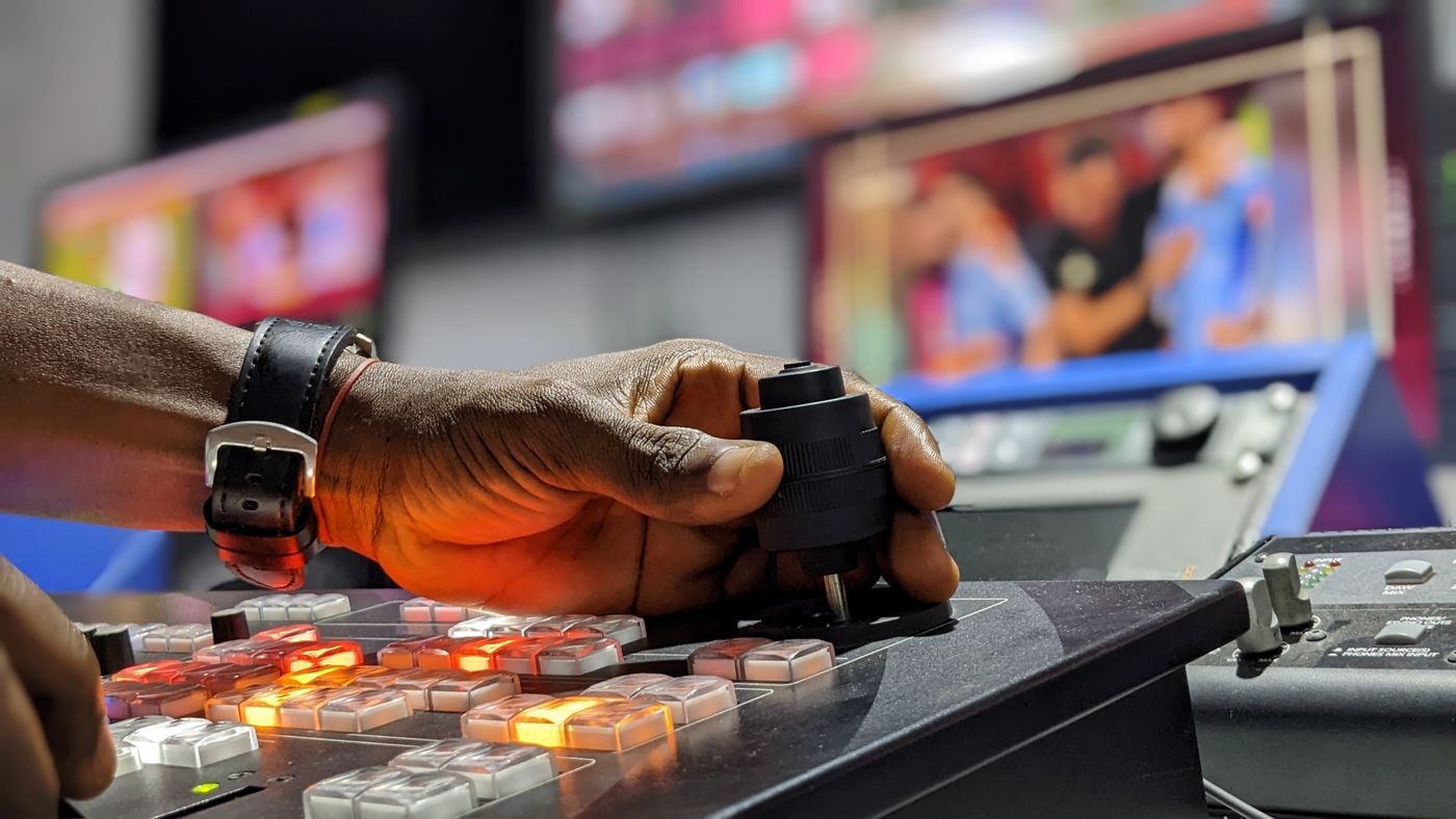 Hand am Mischpult einer Fernsehproduktion